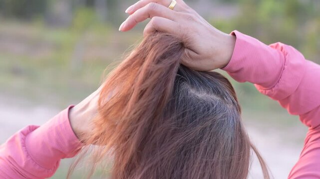 Asian woman's gray hair, Grey color hair of Asian, Regrown gray roots of dyed hair on head of woman, Dry and damaged hair