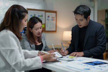Business team analyzing financial data and taking notes during a meeting