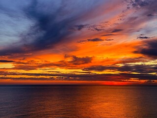 Stunning sunset clouds dramatic sky over sea at night.