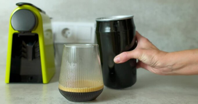 Woman Pouring Frothed Milk into Espresso at Home