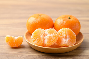 Mandarin tangerine orange fruit on wooden plate ready to eating