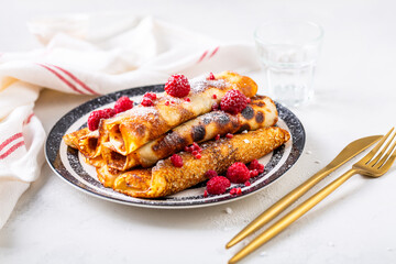 Homemade rolled pancakes, flapjacks filled with cream cheese with fresh berries