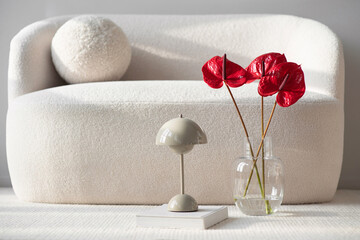 View of modern scandinavian style interior with sofa, lamp and flowers, Home staging and minimalism concept, closeup interior details