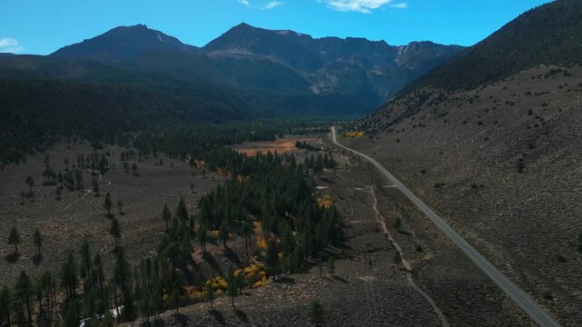 West Portal Entrance Mountains Lee Vining Tioga Pass Road Yosemite National Park California aerial drone Ansel Adams Wilderness Big Oak Flat fall yellow orange Aspen Trees blue skies backwards pan up
