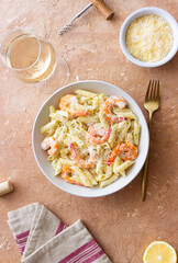 Penne pasta in creamy garlic sauce with shrimps and cheese. Italian food.