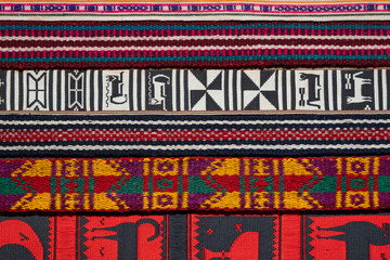 Close-up of traditional Andean woven textiles with intricate geometric and animal patterns in vibrant colors. Ideal for cultural heritage, craftsmanship, and textile design themes.