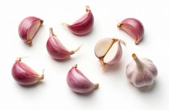 Macro top view photo of collection of fresh garlic cloves on white background. Peeled, unpeeled segments arranged, including one cut in half inner texture. Healthy eating, cooking ingredient.