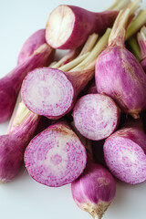 Whole red radishes are displayed with their vibrant purple skin and crisp white interior