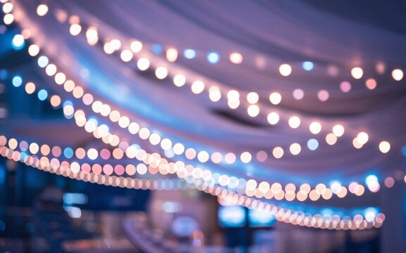 Festive string lights blur indoor party