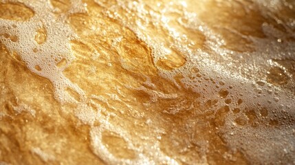 Obraz premium Golden Water Flows Across the Surface with Bubbling White Foam