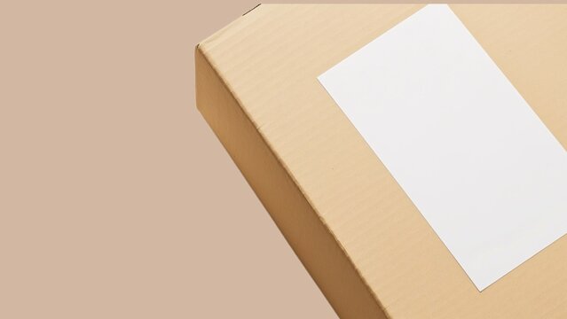 Close-up of blank white label on brown corrugated cardboard box mockup.