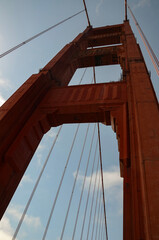 Fototapeta premium Beautiful view of the bridge supports of the famous Golden Gate Bridge with blue sky and clouds on a sunny summer day in San Francisco Bay Area, California, USA