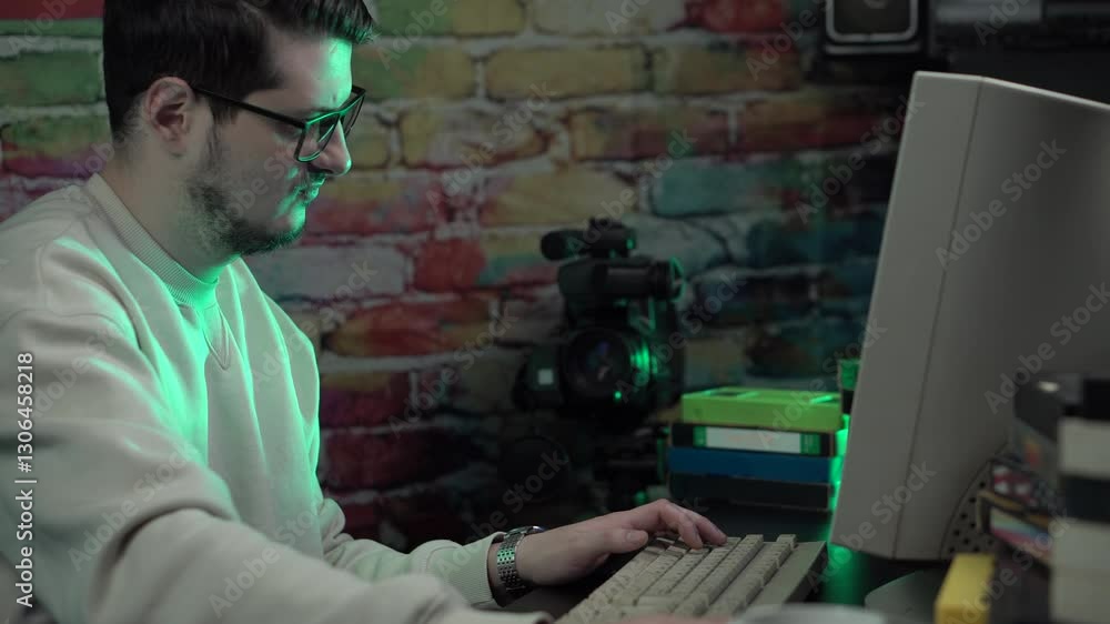Aufkleber it guy from 1990's working on desktop computer surrounded with vhs cassette tapes