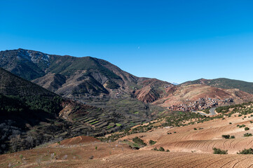 Majestic Atlas Mountains rising over rural landscape in Morocco under clear blue sky