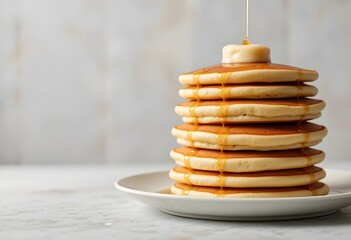 A stack of plain pancakes with a minimal drizzle of syrup. Soft, fluffy texture on a clean background, perfect for breakfast and simple food concepts.