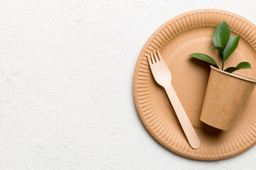 set of empty reusable disposable eco-friendly plates, cups, utensils on light white colored table background. top view. Biodegradable craft dishes. Recycling concept. Close-up