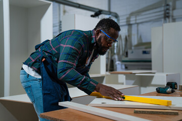 Afro american craftsman working as carpenter in a carpentry workshop