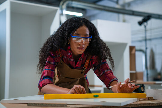 Woman working as carpenter in a small carpentry workshop - Powered by Adobe