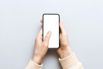 Top view of woman hands holding smart phone with blank copy space screen for your text message or information content. woman hand using phone white screen on top view