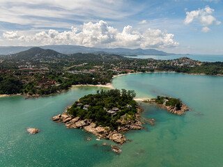 Naklejka premium A tropical island with rocky shores and turquoise water under a sunny sky. Koh Samui, Thailand.