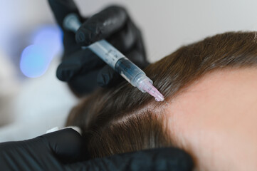 Man getting hair treatment at beauty salon, having mesotherapy session. Female therapist hands in protective gloves making injection with syringe