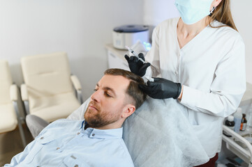 Trichologist giving injection to patient in clinic, closeup