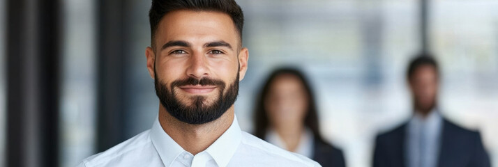 Professional man smiles confidently in business setting, showcasing teamwork and collaboration. His presence reflects leadership and positivity in workplace
