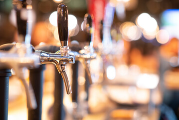 Obraz premium Close up beer pumps at the night club. Chilling and meeting with friend concept.