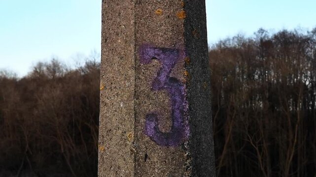 The number three is written in purple paint on a pillar. Serial number 3. Pole numbering. The third item. Numerical designation. Informational mark. High quality FullHD footage.