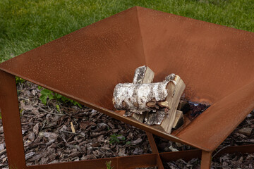 Fireplace in the garden on the green lawn. A glamping or backyard recreation area.