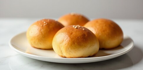 Freshly baked milk buns arranged in a row on a plate, round, homemade