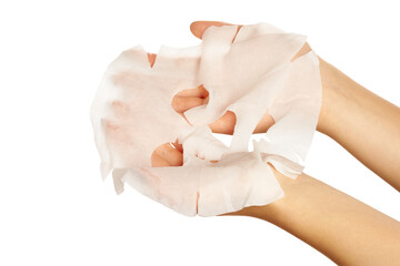 hands holds a used sheet mask that appears slightly crumpled and translucent.skincare, hydration, and beauty routines.