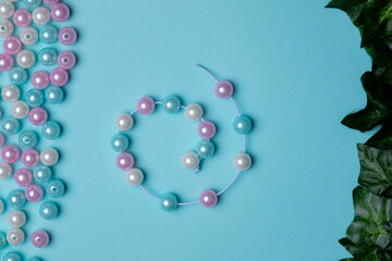 Colorful beads arranged on a blue background with a bracelet created from similar beads