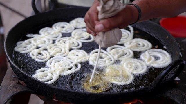 indian traditional sweet jalebi frying at local street market at night