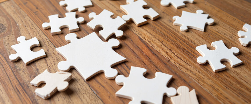 White puzzle piece highlighting absence on wooden tabletop, symbolism of completeness