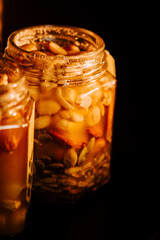 Jars filled with colorful seeds and fruits in a warm ambiance, showcasing a unique preservation method in a cozy setting
