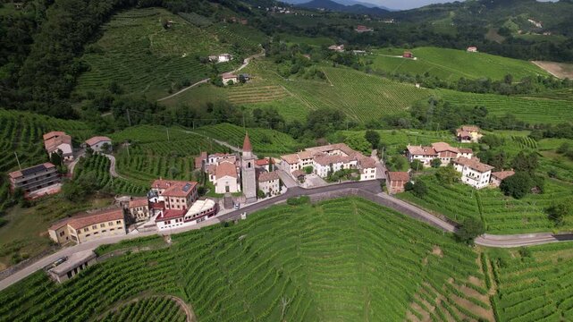 DRONE FOOTAGE: Famous Prosecco Hills in Veneto wine region. View of vineyard Prosecco and the Chiesa di Rolle church in Rolle, a small hamlet of Cison di Valmarino, Valdobbiadene, Veneto, Italy.
