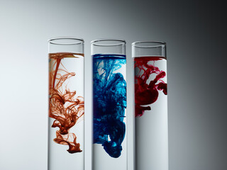 Paint drop in glass over grey gradient background. Chemical industry