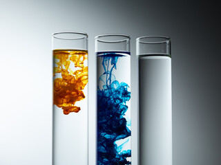 Paint drop in glass over grey gradient background. Chemical industry