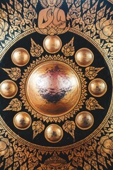 Intricate golden gong with Buddhist motifs and ornate patterns in a temple setting.