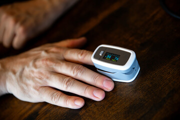 an adult man measures his oxygen level on his finger