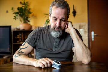 an adult man measures his oxygen level on his finger
