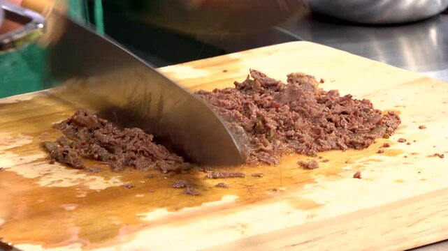 Chopping cooked bulgogi on a wooden board
