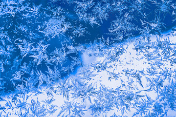 Frosty blue texture on window glass creating an abstract winter background with copy space