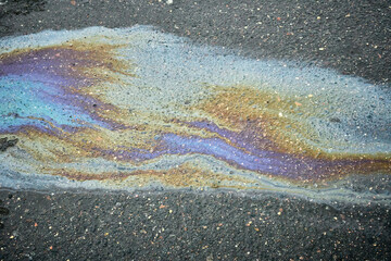 Oil Slick Creating a Colorful Pattern on Asphalt Surface After Rainfall in an Urban Area