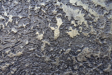 Close shot of glossy gray and gold wall with decorative stucco finish