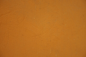 Uneven surface of bright orange painted wall