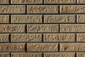 Close shot of sand brown split face brick veneer wall with stretcher bond