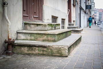 Old Concrete Steps with Moss and Rusty Pipe on Urban Street