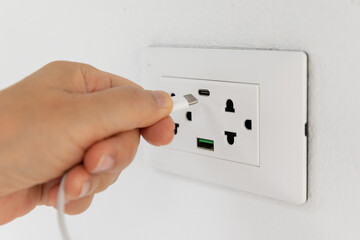 Mobile device is charging on USB-C wall socket.